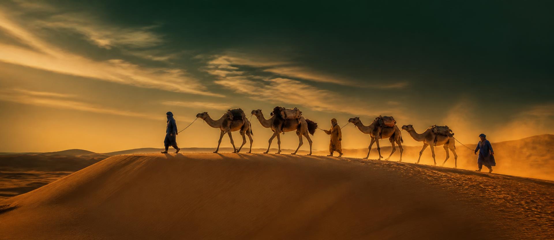 Caravane de chameaux et voyageurs traversant les dunes du Sahara au coucher du soleil
